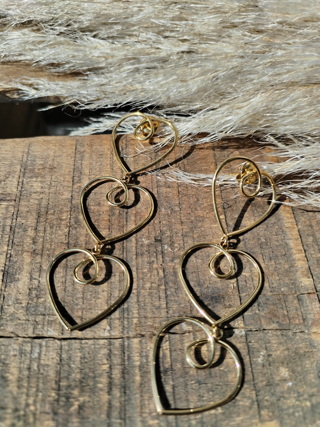 Boucles d'oreilles dorées trois cœurs reliés