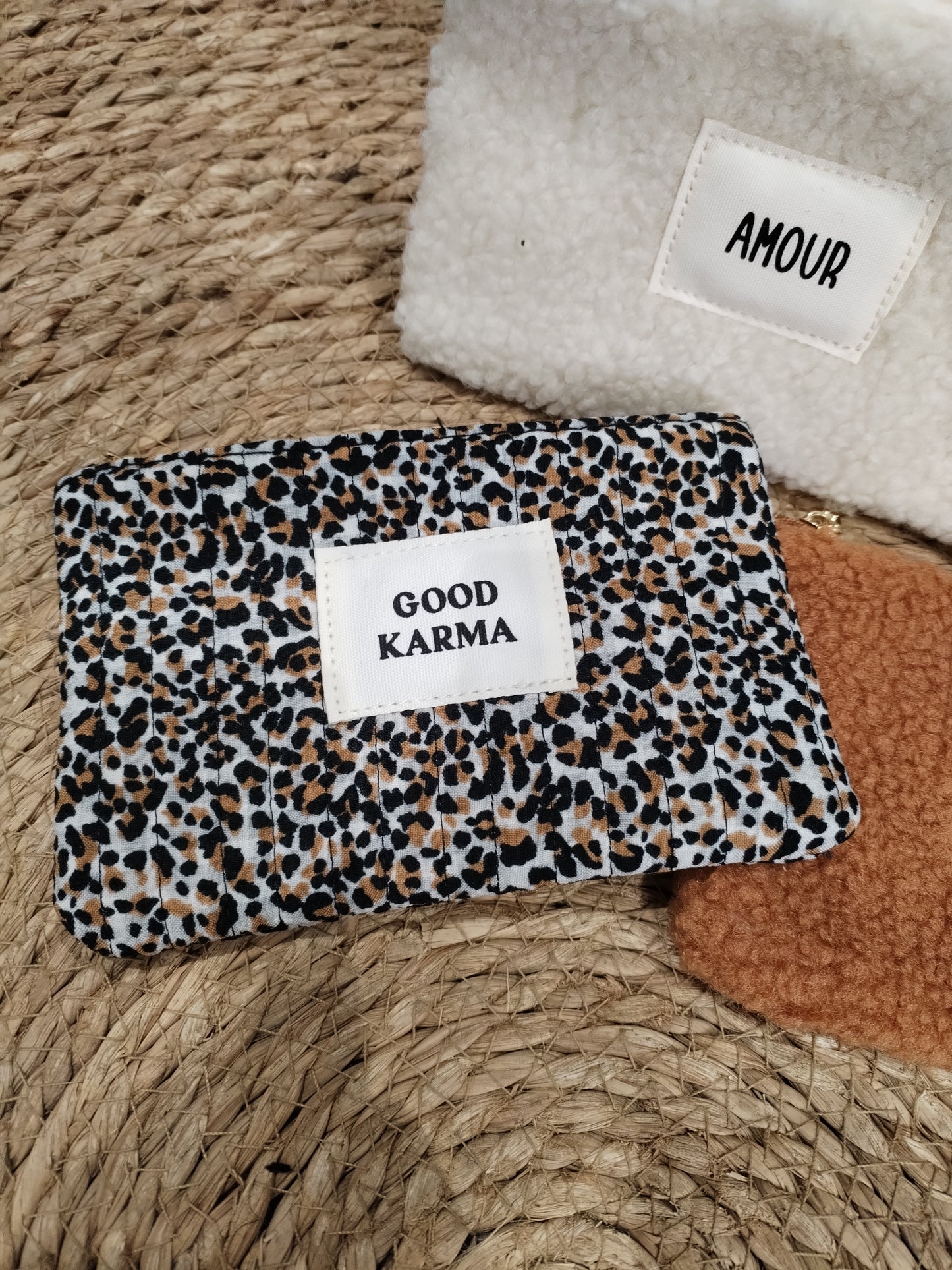 Pochette léopard clair avec inscription dorée "Good Karma"